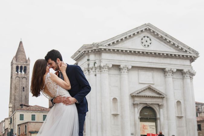 Just married couple kissing beside the church outdoor
