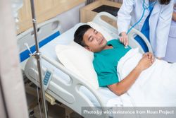 Physician visiting sick man in hospital bed 5rllnb