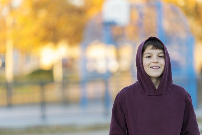 Smiling teen boy wearing hoodie outdoors