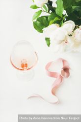 Glass of pink rose wine in the center with flowers and ribbon 5lgza0