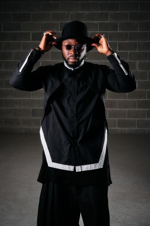 Stylish man standing in dark room
