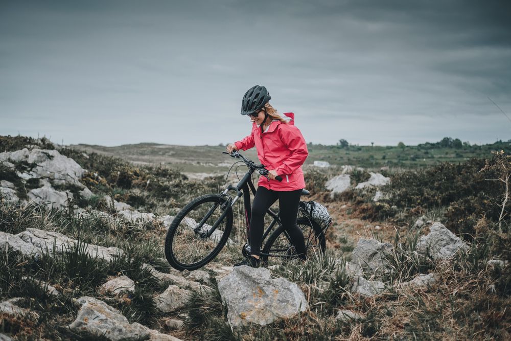 Anonymous female bicyclist on rocks