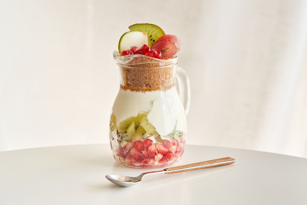 Delicious yogurt dessert with pomegranate, kiwi, grape and ginger biscuit