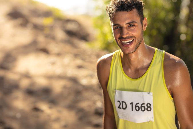 Smiling male athlete in mountain trail race