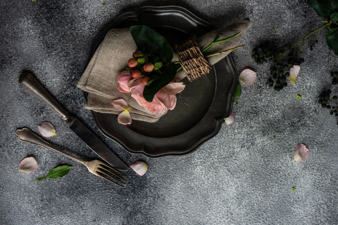 Delicate pink flowers on grey napkin and plate with space for text