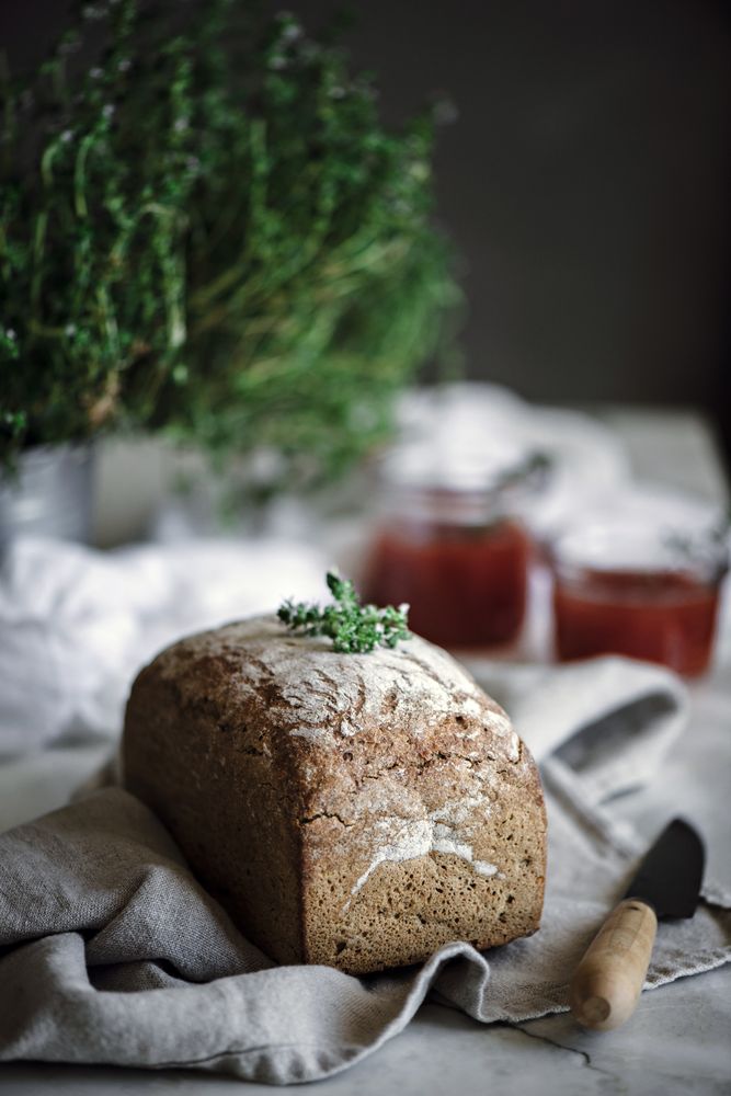 Fresh bread on napkin near tomatoes jam