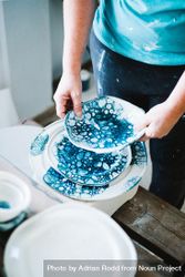 Person browsing different plates in ceramic shop 4ZXXy0