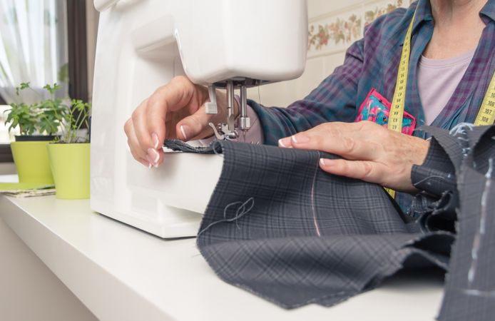 Mature seamstress woman working on sewing machine