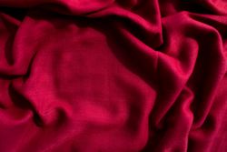 Red fabric wavy crumpled background texture with copy space.