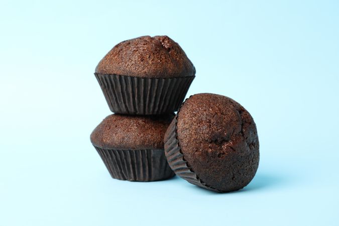 Delicious tasty chocolate muffins on blue background