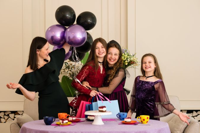 Teen with woman and two young girls. Birthday Party