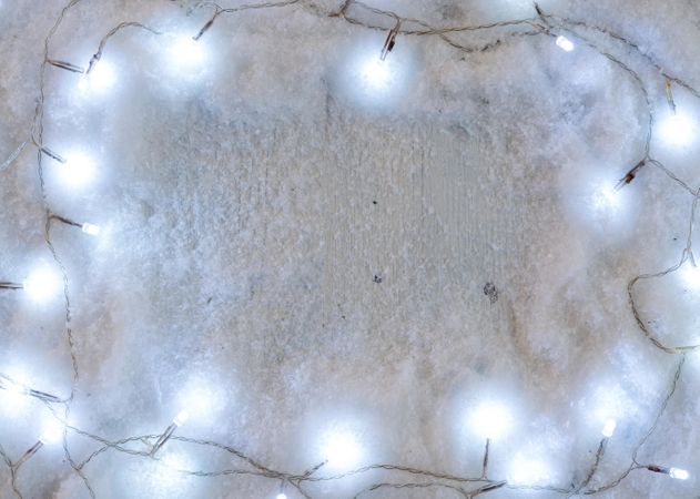 Snowy background composition with decorative Christmas lights