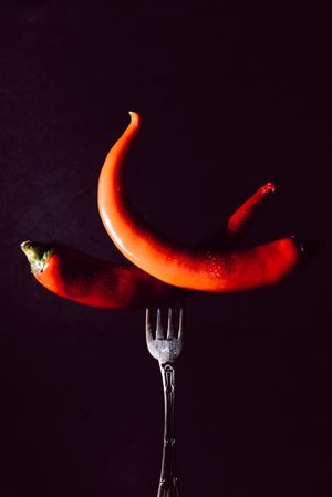 red chili peppers in fork on a dark background