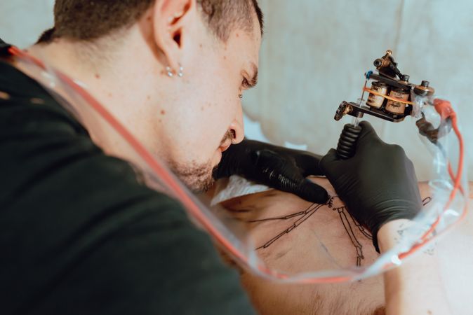 Stylish man drawing tattoo