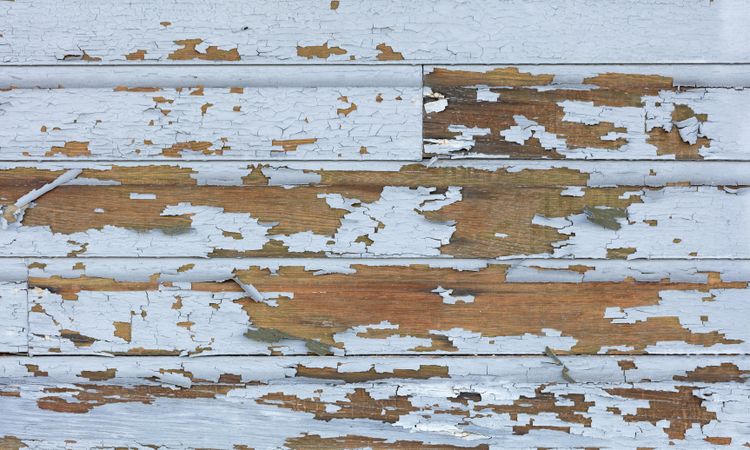 Old lead paint peeling off of wood sliding exterior