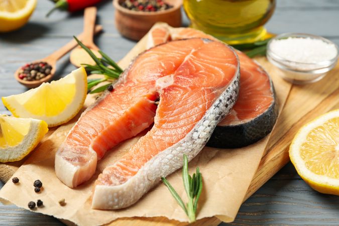 Composition with salmon meat and spices on wooden background, close up