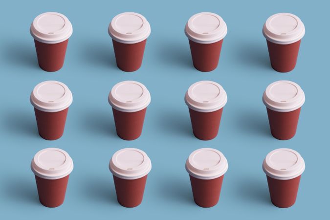 Top view of disposable coffee cups on blue background