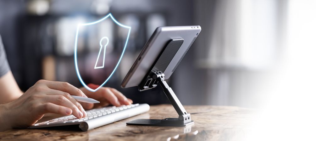 Man working on tablet with cybersecurity icon