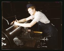 Milwaukee, WI, USA - 1943: Woman leaning over gun manufacturing machinery 4mZkzb