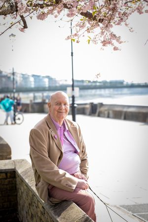 Man sitting on wall near river