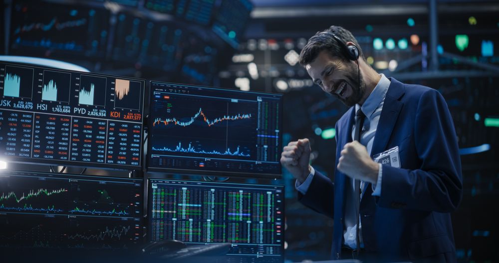Professional Broker Hears the Good News on a Call in His Headset, Punches the Air in a Winning Fashion, Showing Positive Emotions