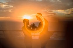 Young people kissing in sunset light on ship