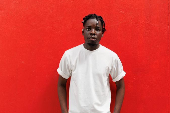 Black man standing with red background