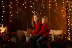 Siblings sitting in wooden horse swing during christmas
