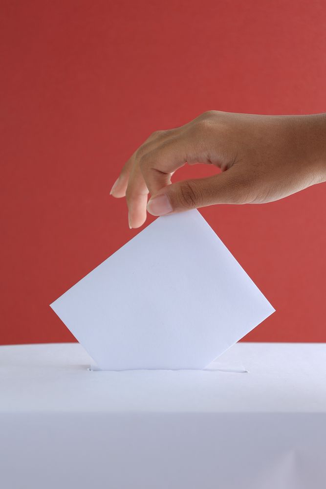 Female Hand Voting Near Ballot Box on Red Background