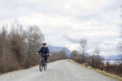 Woman riding a bicycle around a lake