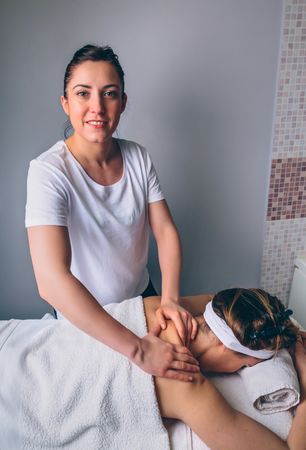 Smiling massage therapists giving massage to client