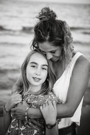 Beautiful mother and daughter embracing on beach