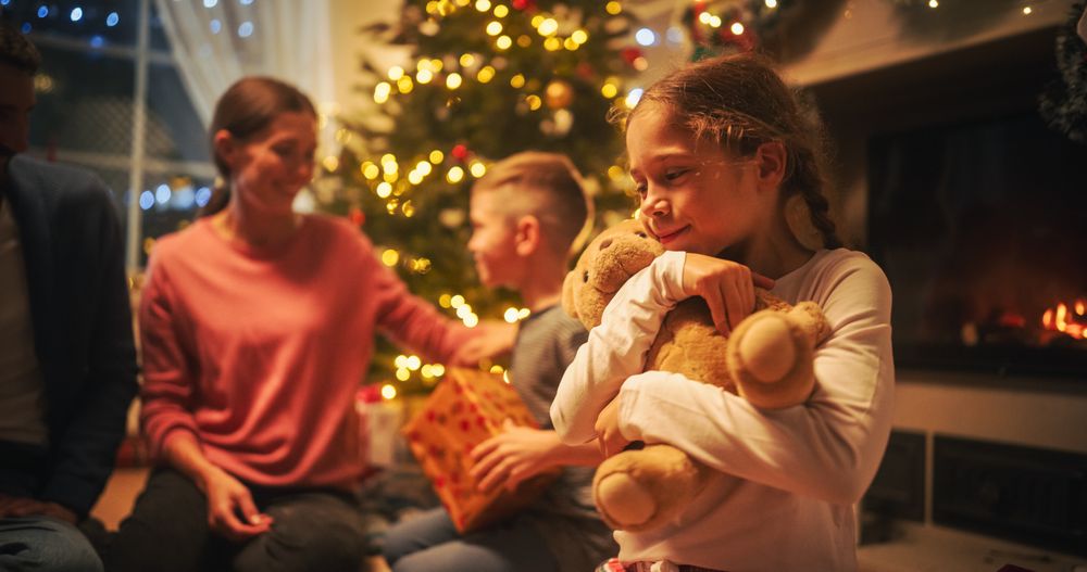 Loving Young Parents Giving Gifts to Their Children on Christmas Eve.