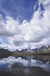 Cloudy sky over calm lake and mountains