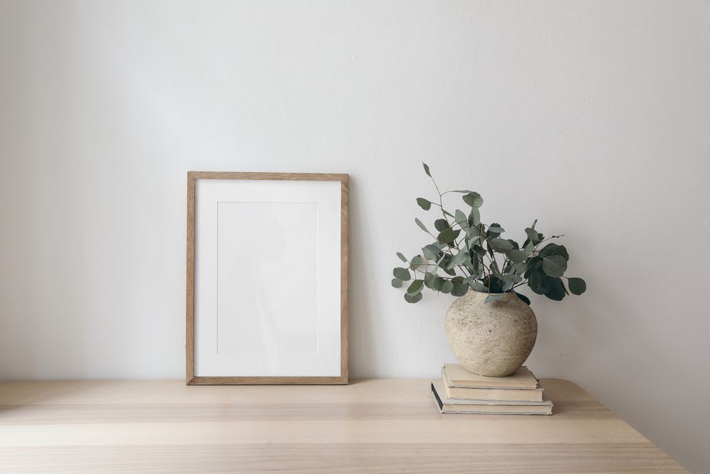 Mock up poster on table with vase and eucalyptus leaves