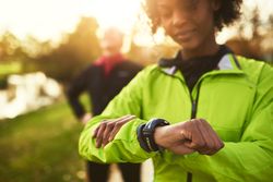 Woman checking smartwatch in a sunny park