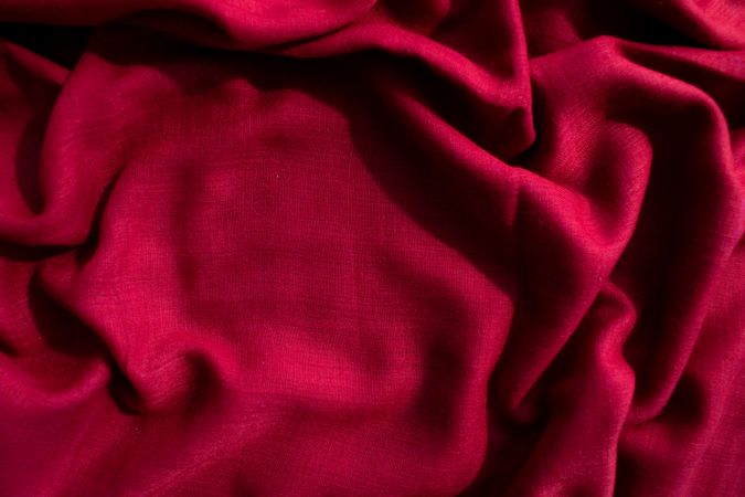 Red fabric wavy crumpled background texture with copy space.