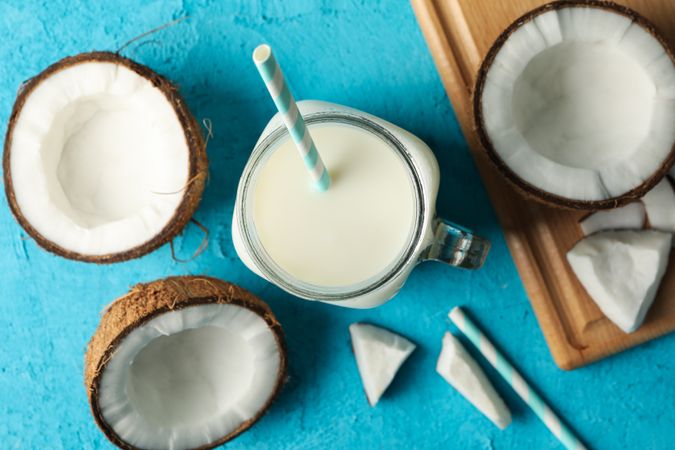 Coconut and milk on blue background, top view