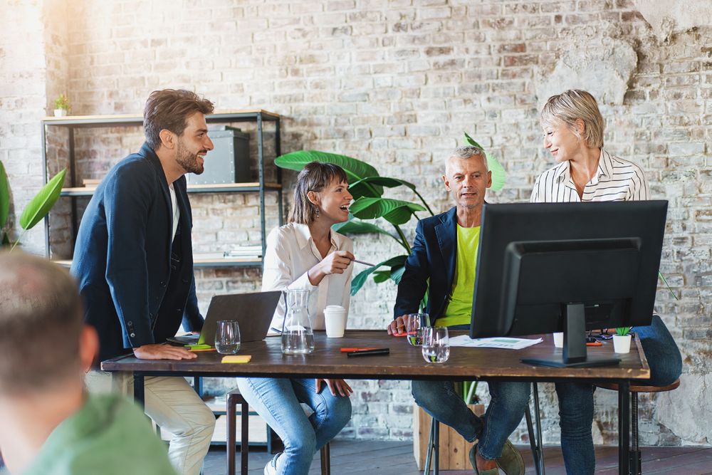 Corporate creative professionals collaborating together on computers