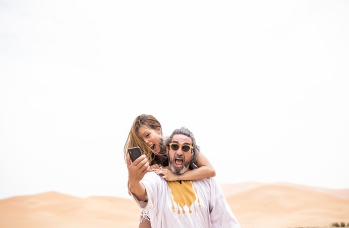 Laughing couple taking selfie on exotic terrace