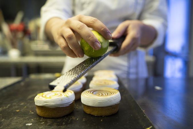 Cook grating lime on meringue cookies
