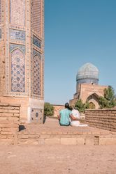 Couple sitting outside ornamental building
