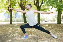 Sporty man stretching up in park