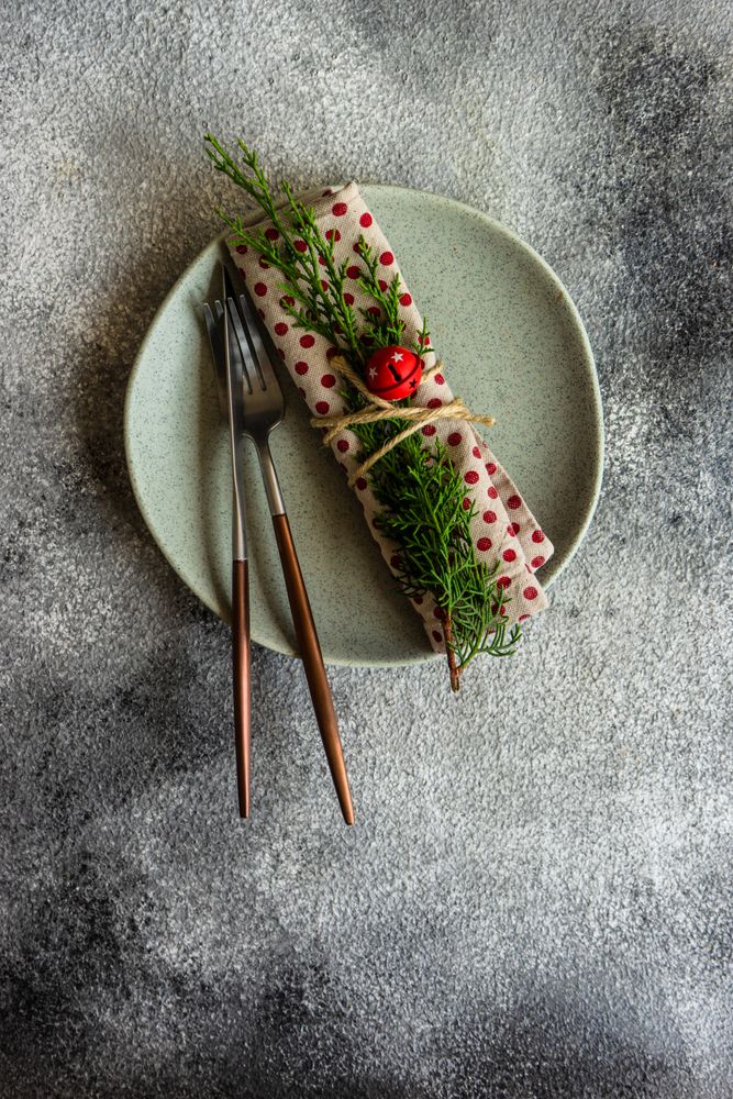 Top view of rustic table setting for Christmas dinner of dotted napkin with branch