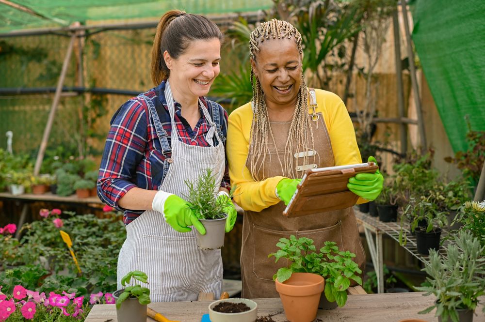 Diverse gardeners using tablet together