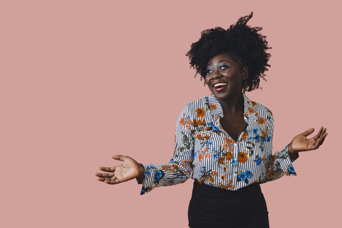 Portrait of smiling Black woman looking to the side with her arms open