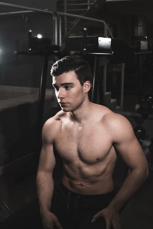 young fitness man resting in the gym