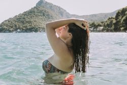 Woman resting in water on seashore