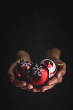 Crop person showing Christmas baubles