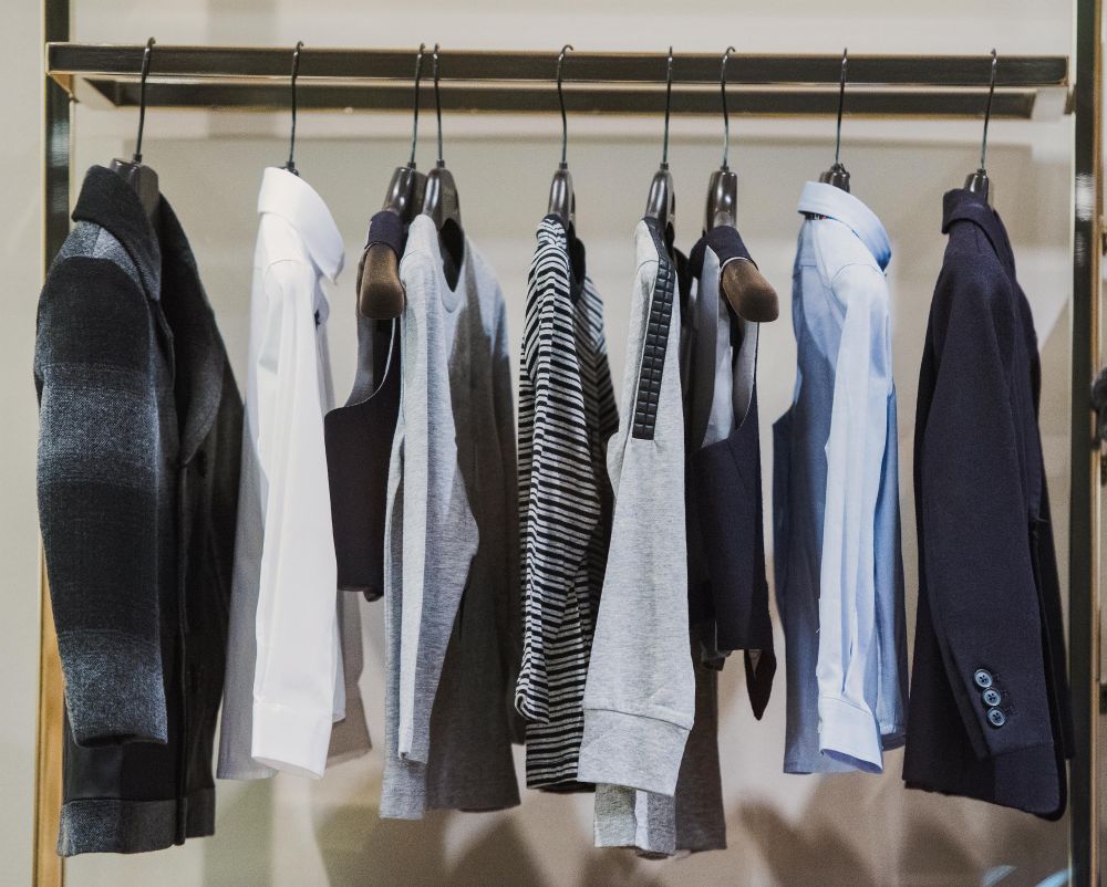Clothes rack of sweaters and shirts in fashion store